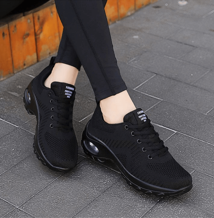 Woman wearing stylish black breathable flexible women's sneakers SF0775 with mesh air upper and EVA insole on pavement.